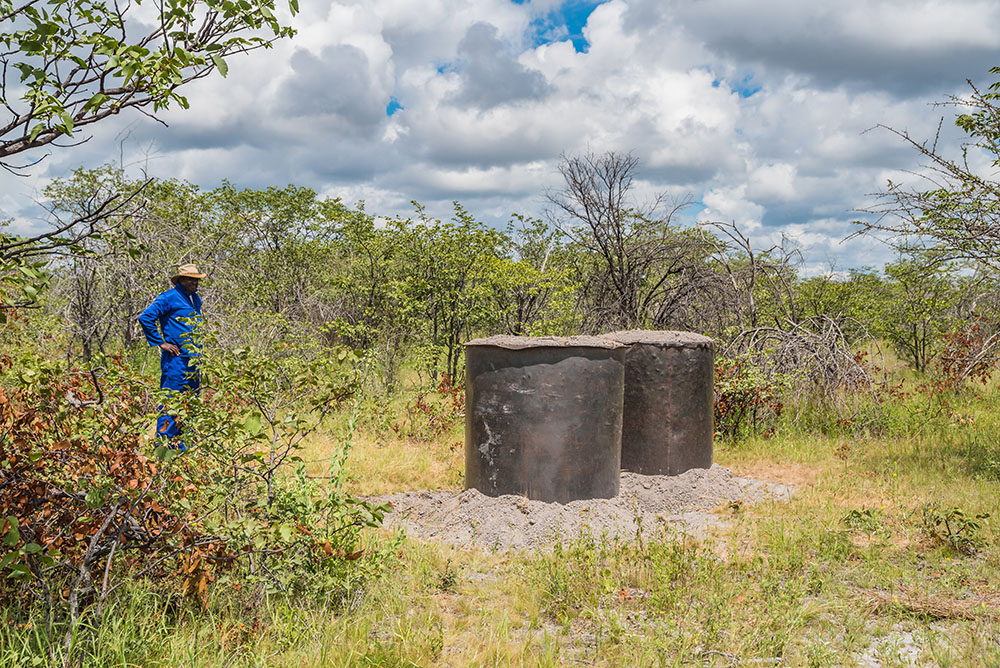 Mbati standing in front of some of his charcoal kilns ready for burning