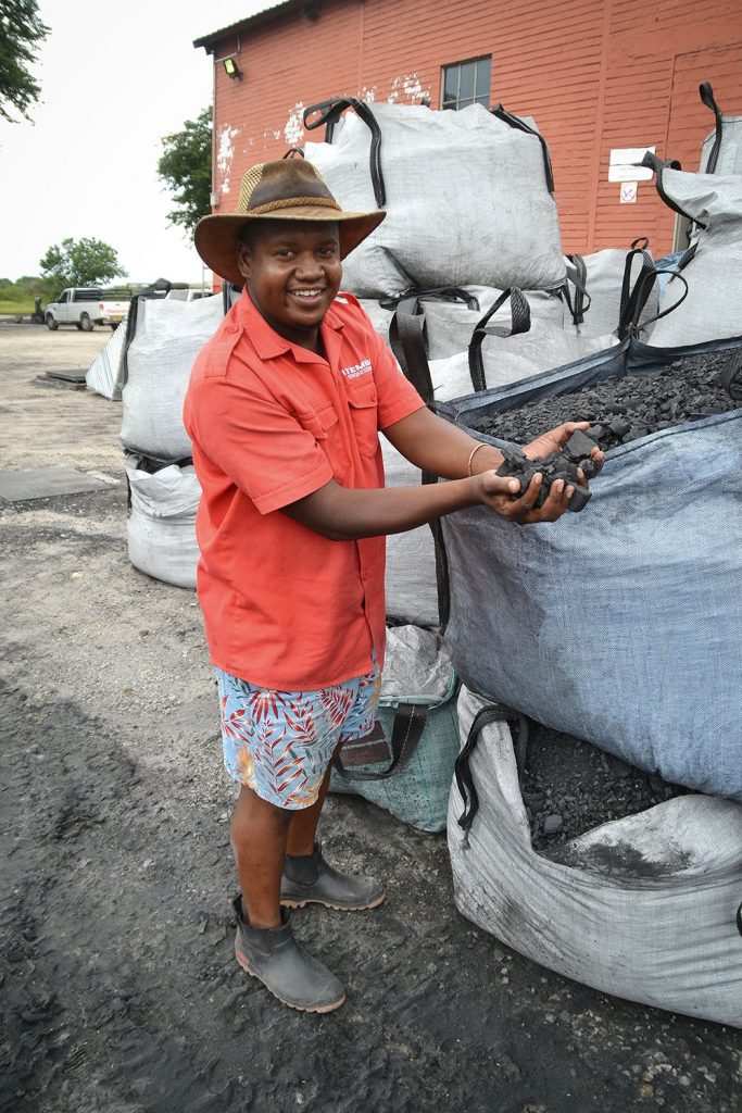 Matti Intamba proudly shows off their charcoal production